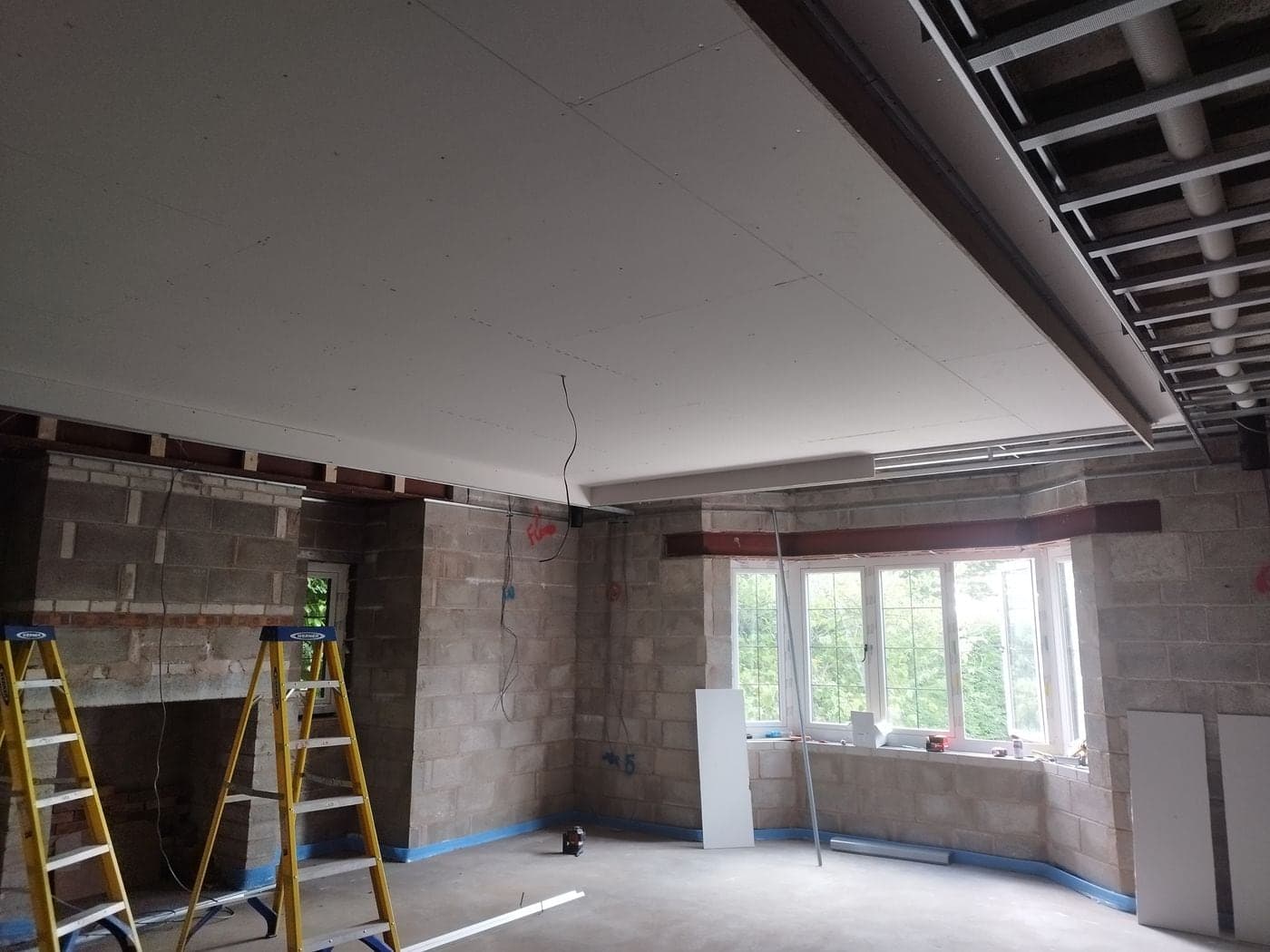 Plasterboard being fixed to the MF ceiling framework in Prestbury, Cheshire