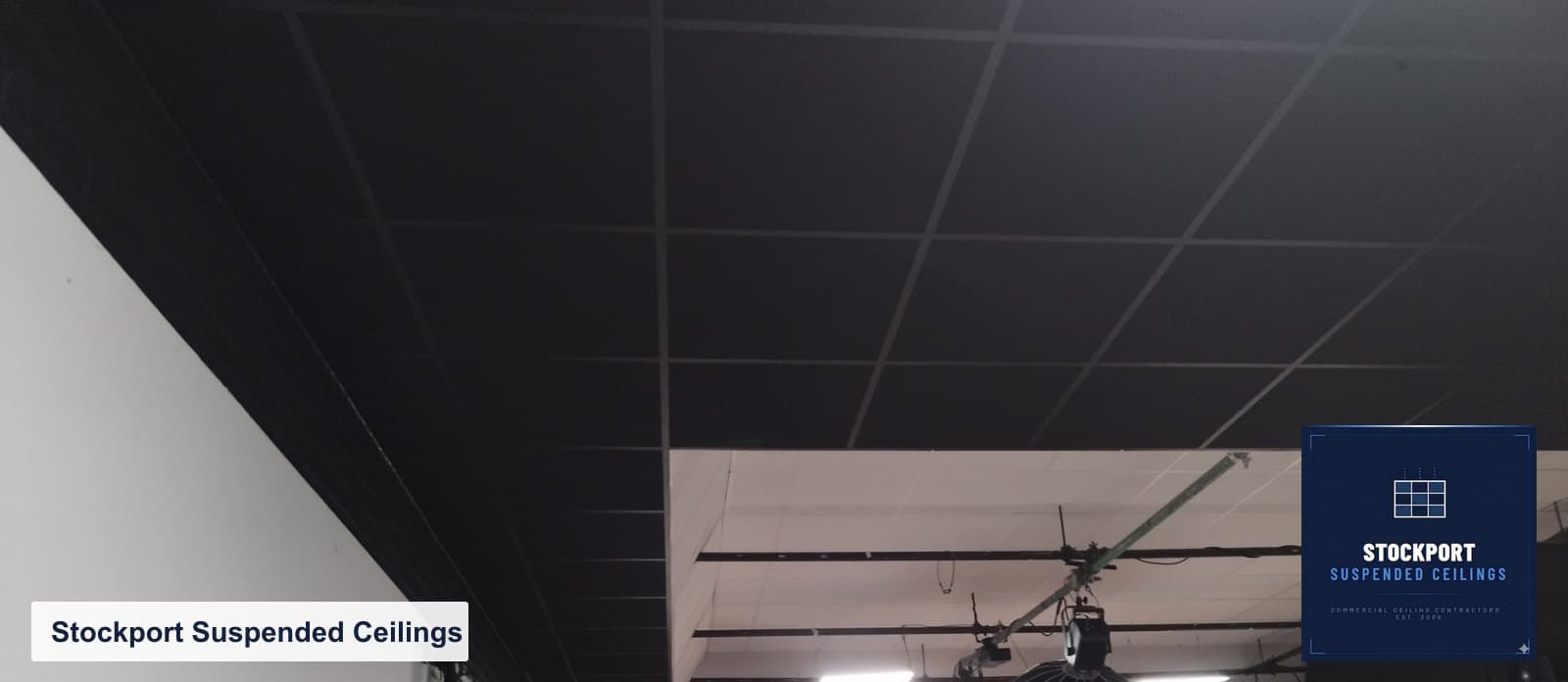 Completed black acoustic tile and grid ceiling in a recording studio