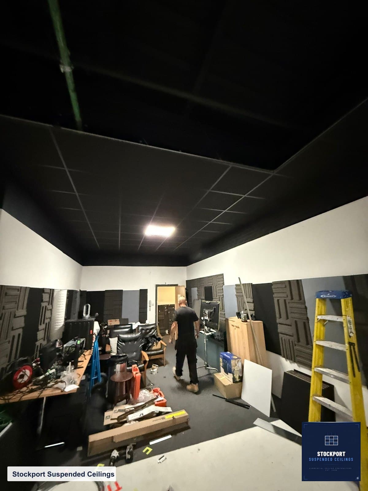 Black grid acoustic ceiling being installed in a Stockport recording studio