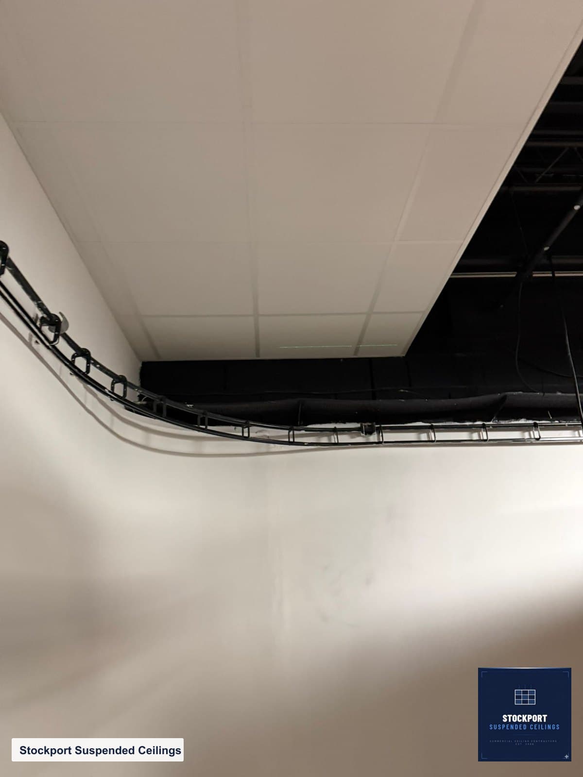 Perimeter detail where the acoustic ceiling meets the wall, cut and sealed tight